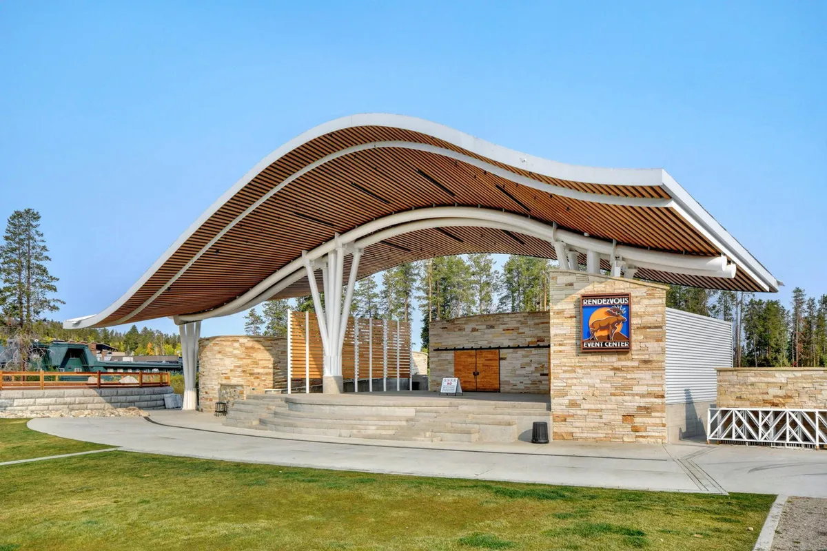 This photo showcases the distinctive curved roof and open stage of Hideaway Park's amphitheater, surrounded by stone walls. The venue is set for concerts, community events, and gatherings, reflecting the area's focus on entertainment and outdoor fun for all ages.